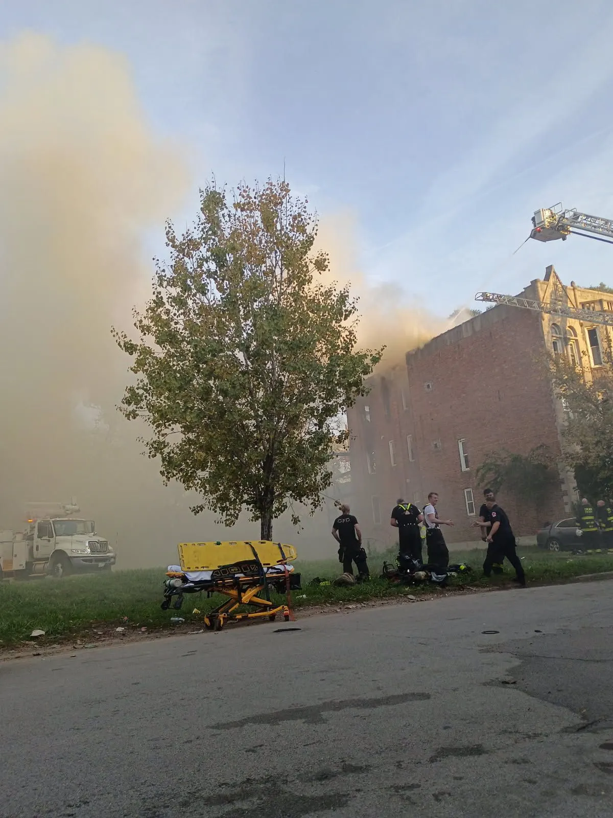 Daytime smoke with people gathered on the lawn