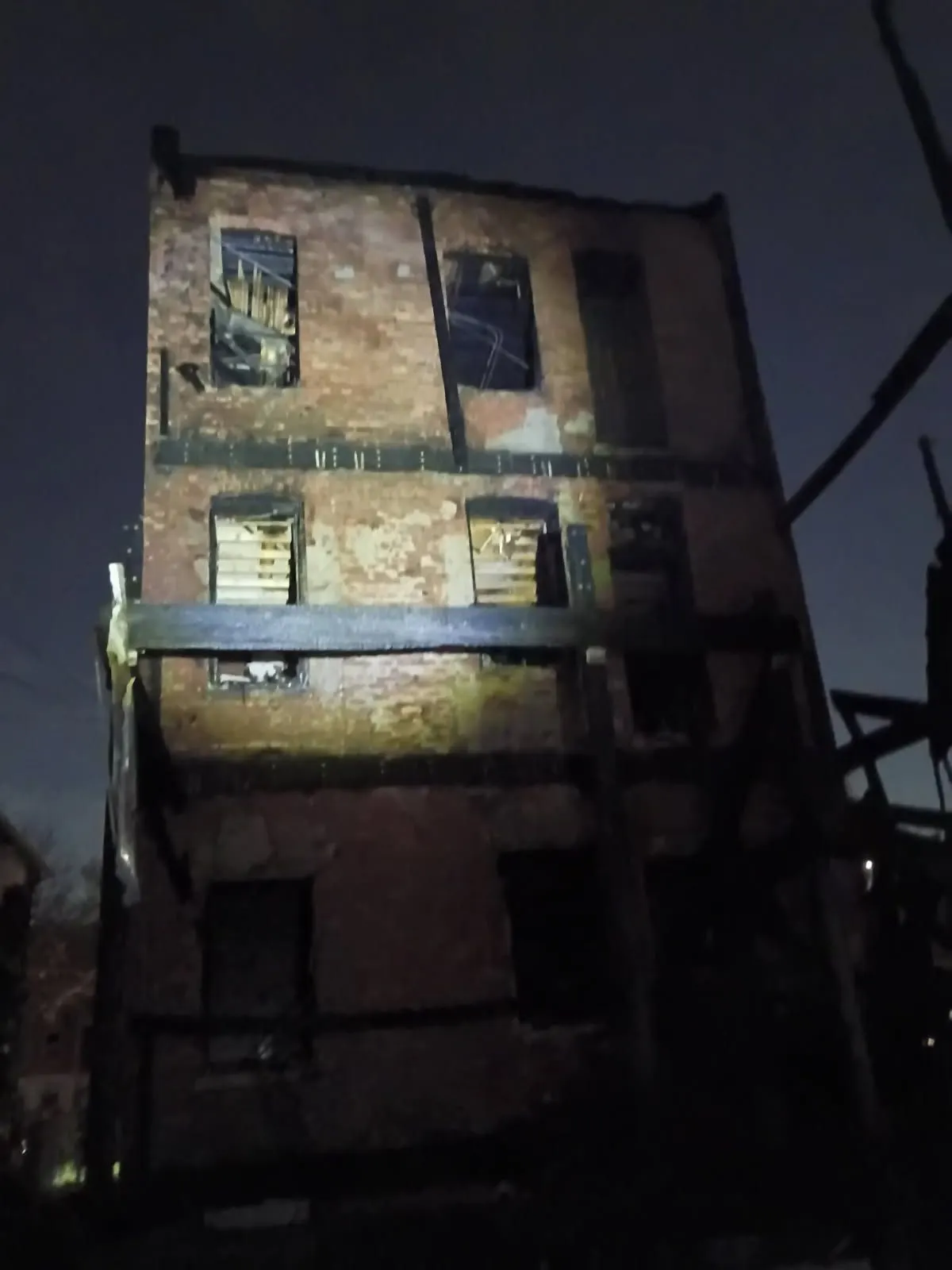 The fire-damaged building at night